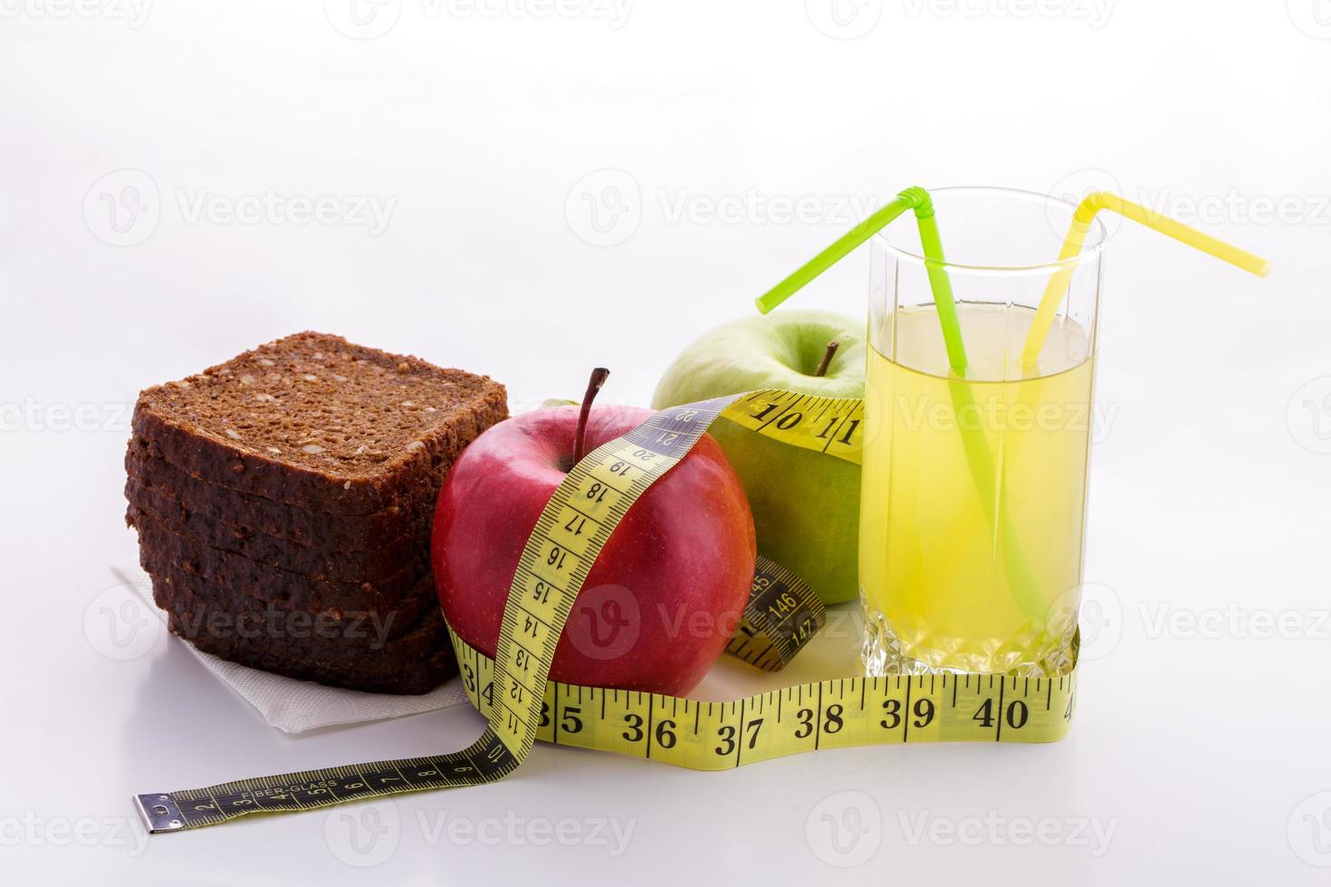 Rye bread apples and juice in  glass on a white background with a measuring tape photo