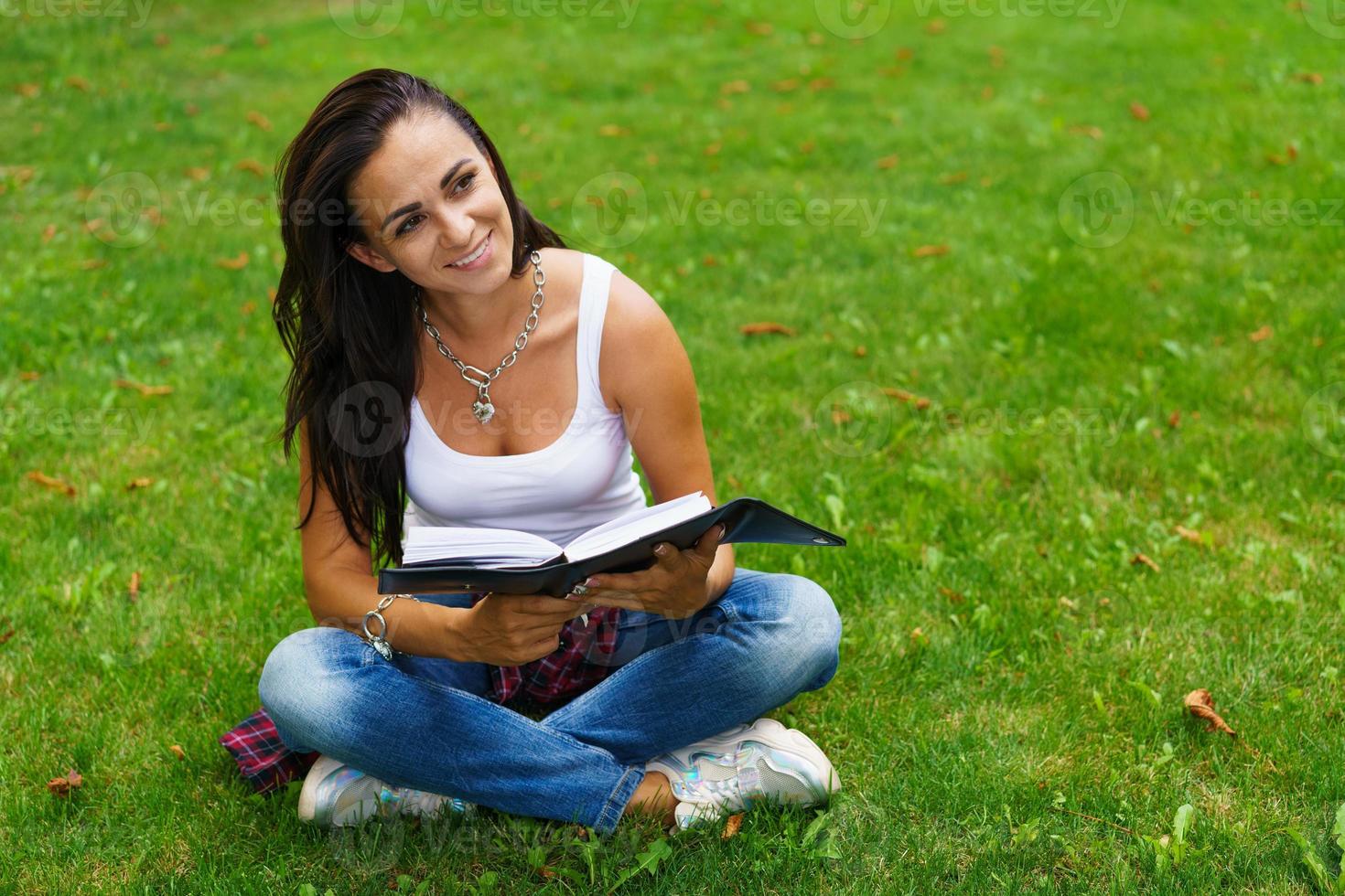 Caucasian woman thinks and writes notes in a notebook, attractive photo