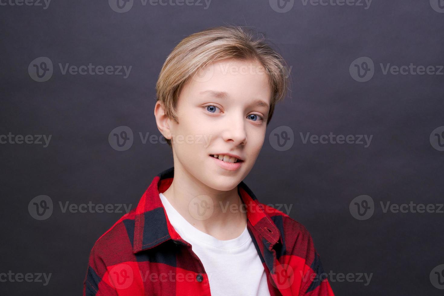 Close-up young smiling man in casual clothes in a red checkered shirt, posing photo