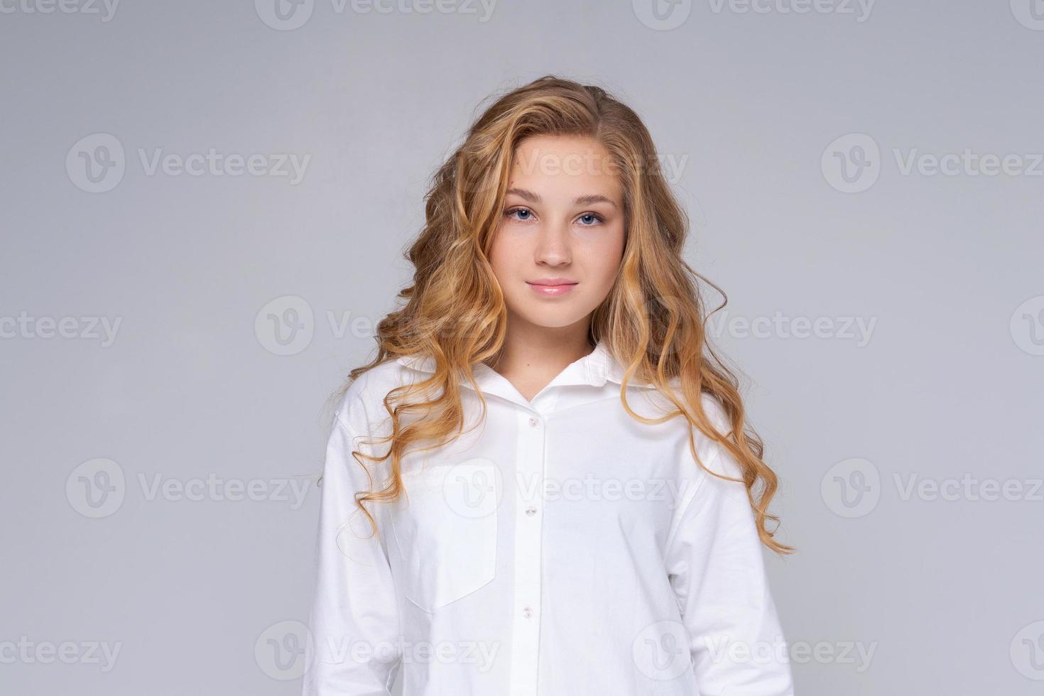 Caucasian girl, happy woman with blond long hair. In a white shirt. Makeup. photo