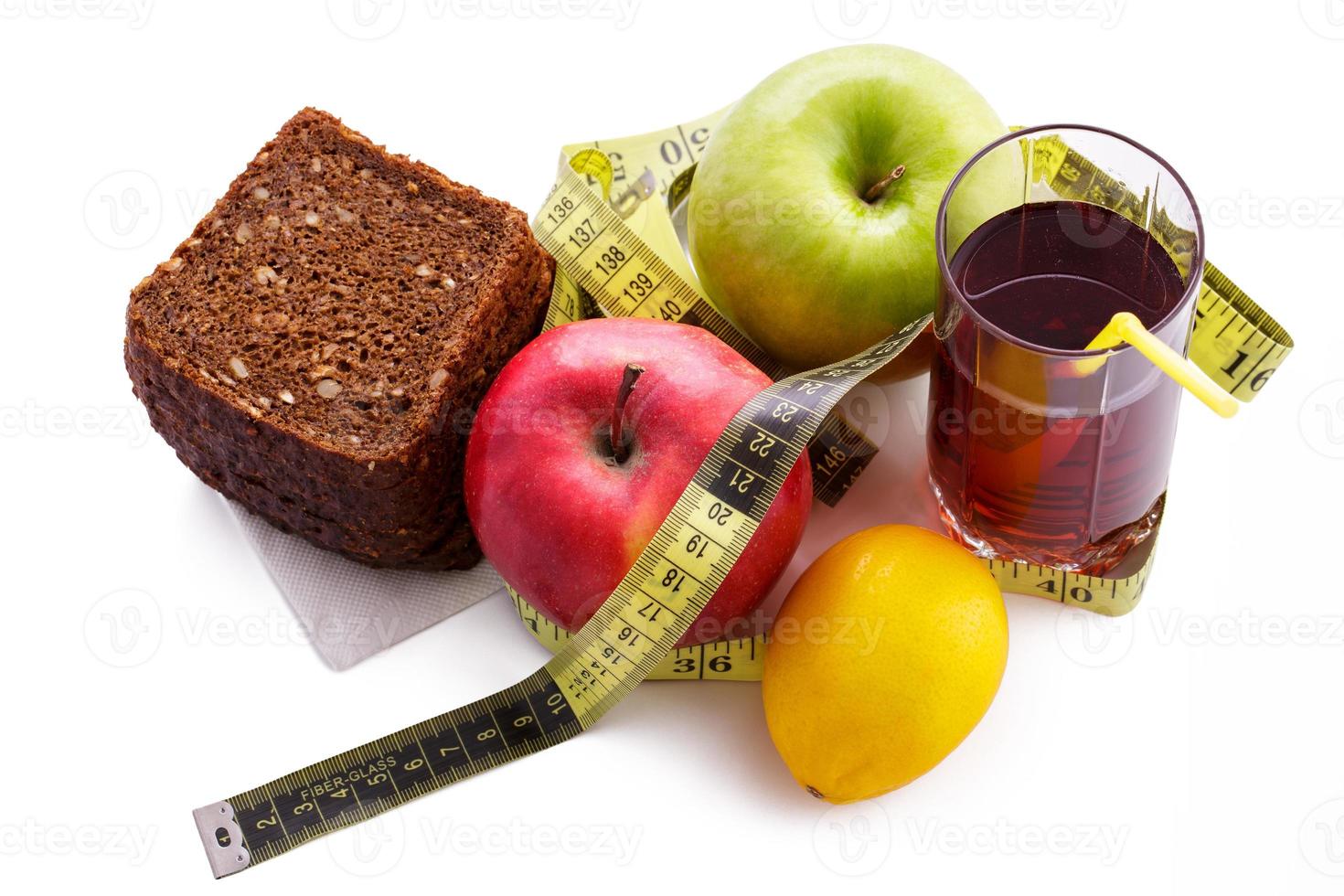 Rye bread apples and juice in  glass on a white background with a measuring tape photo