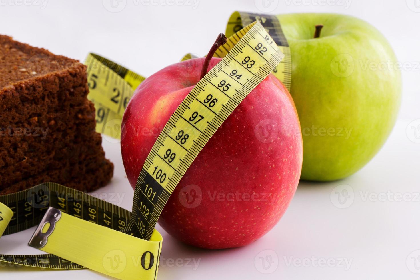 pan negro y manzanas sobre un fondo blanco con cinta métrica foto