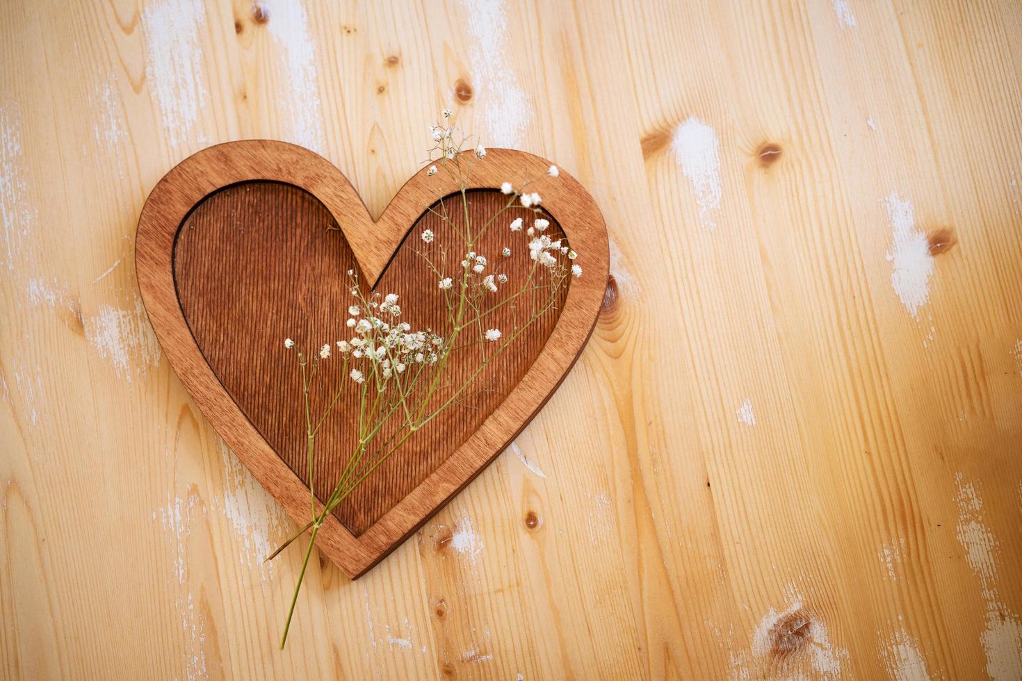 wooden heart lies on a wooden background photo