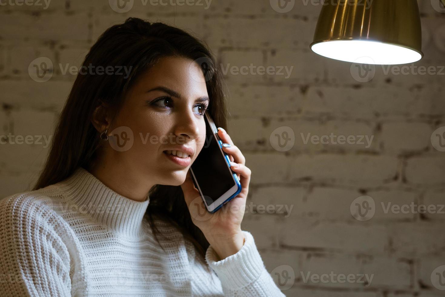 linda joven morena hablando por teléfono foto