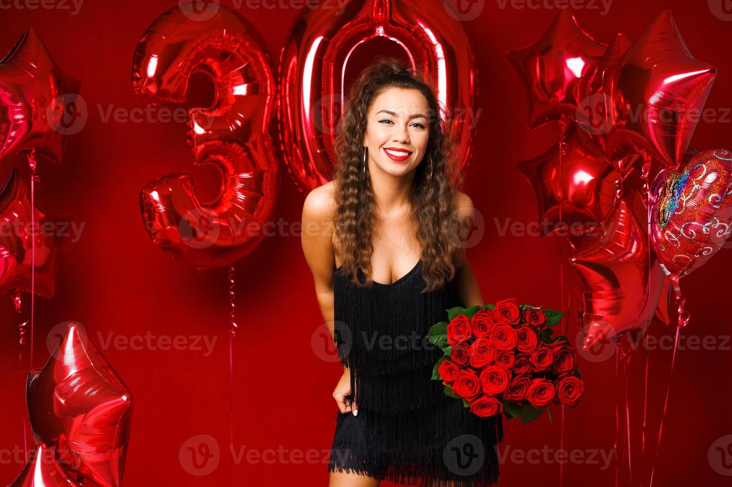 mujer adulta joven en el fondo de globos rojos foto