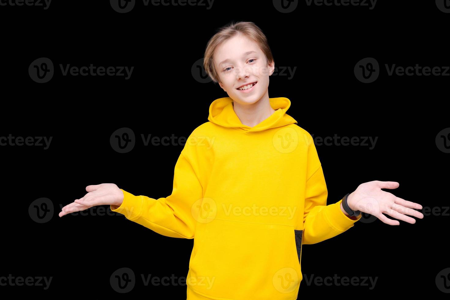 Young smiling happy cheerful man in bright yellow sweatshirt pointing photo