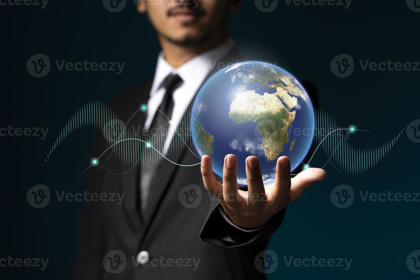 Businessman holding the world in the palm of hands concept for global business photo