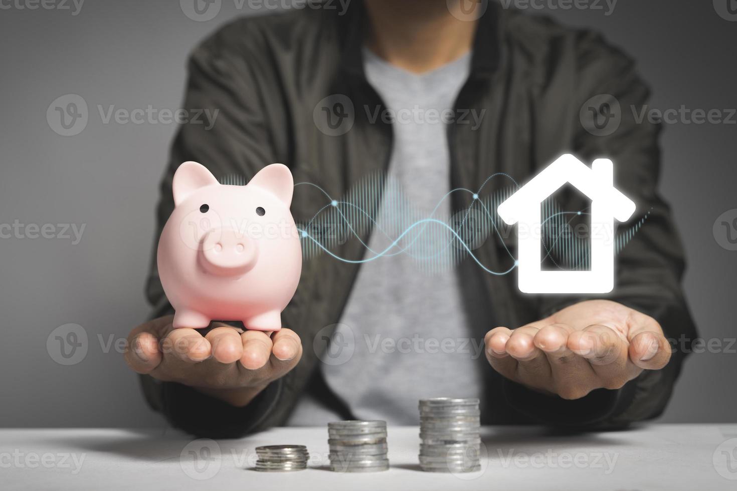 Hands holding a piggy bank and a house icon. Housing industry mortgage plan and residential tax saving strategy photo
