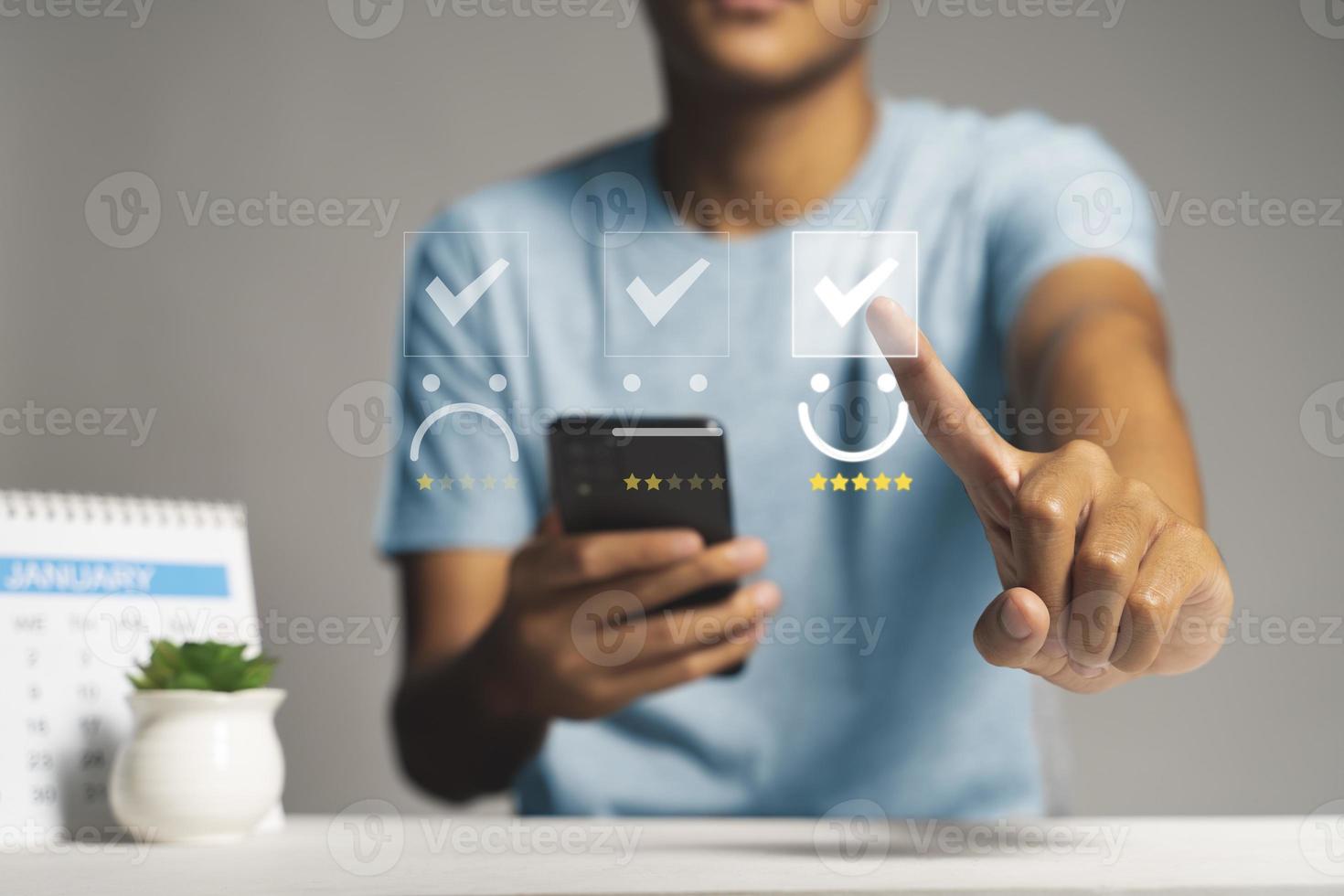 Customer satisfaction survey concept, Man using Smartphone select smiley face icon with yellow five stars photo