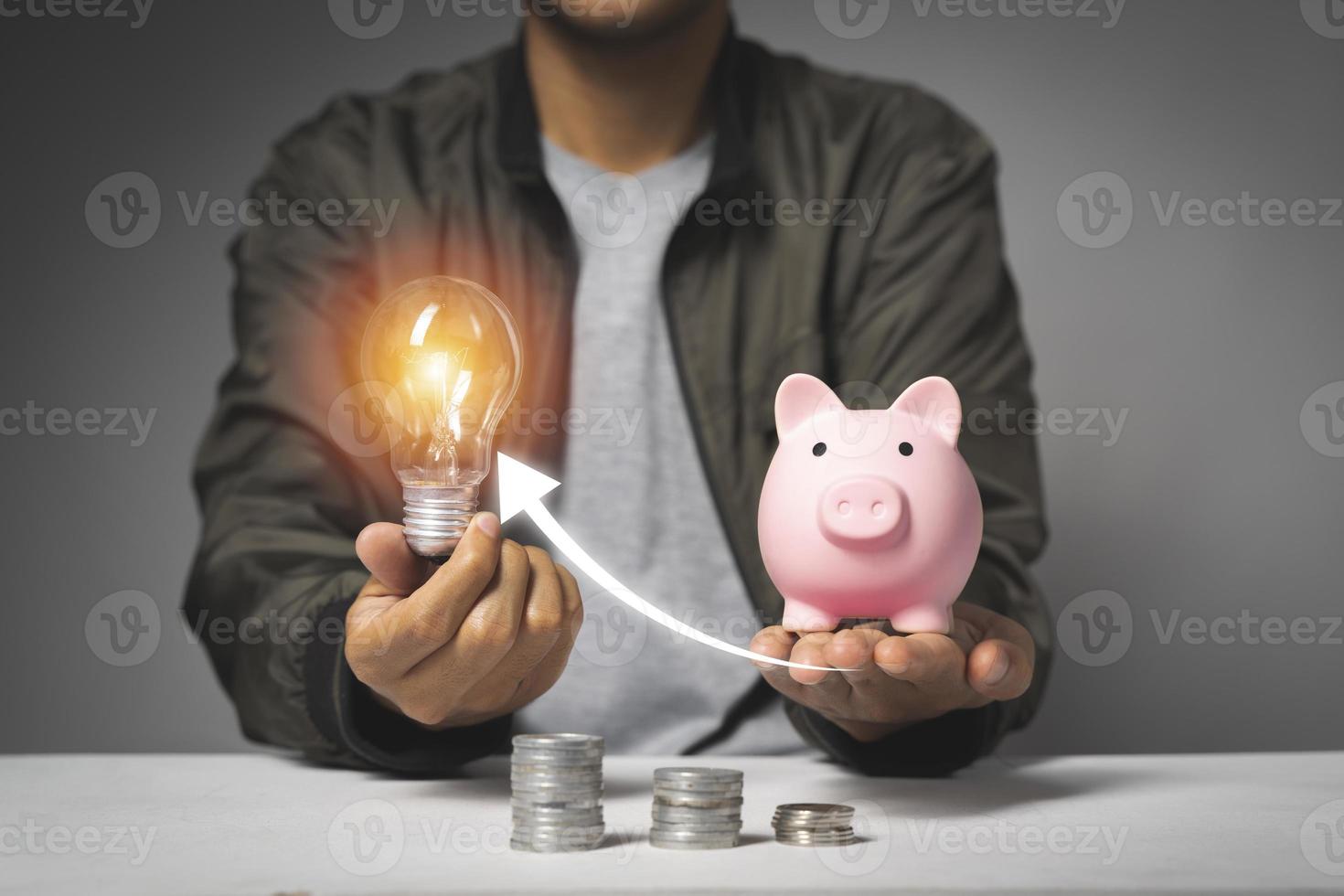 hombre poniendo monedas en la alcancía con monedas en crecimiento. concepto de ahorro de dinero foto