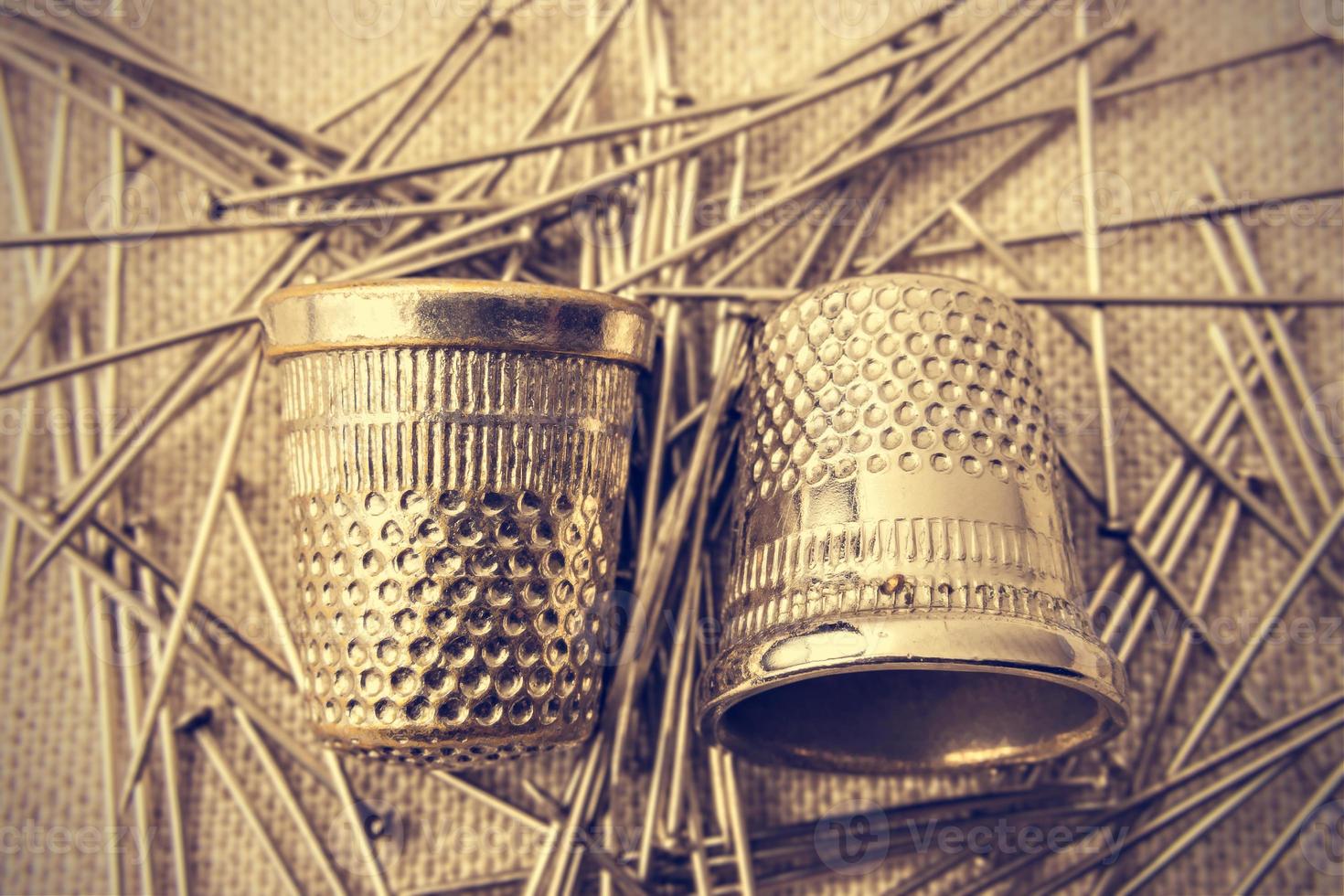 Pins and thimbles on a piece of cloth seen from above. Vintage style. Horizontal image. photo