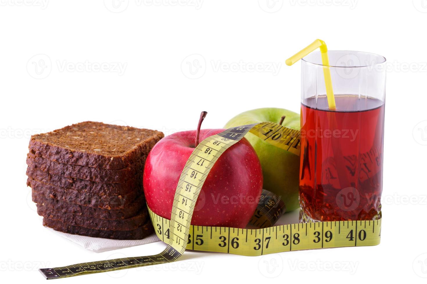 Rye bread apples and juice in  glass on a white background with a measuring tape photo
