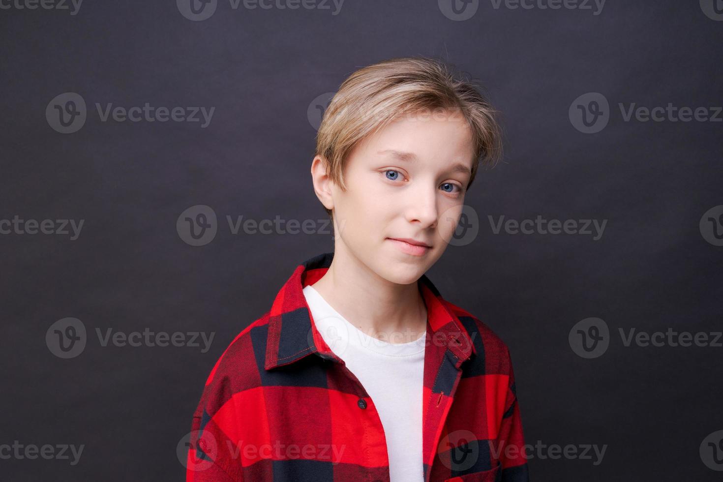 Close-up young smiling man in casual clothes in a red checkered shirt, posing photo