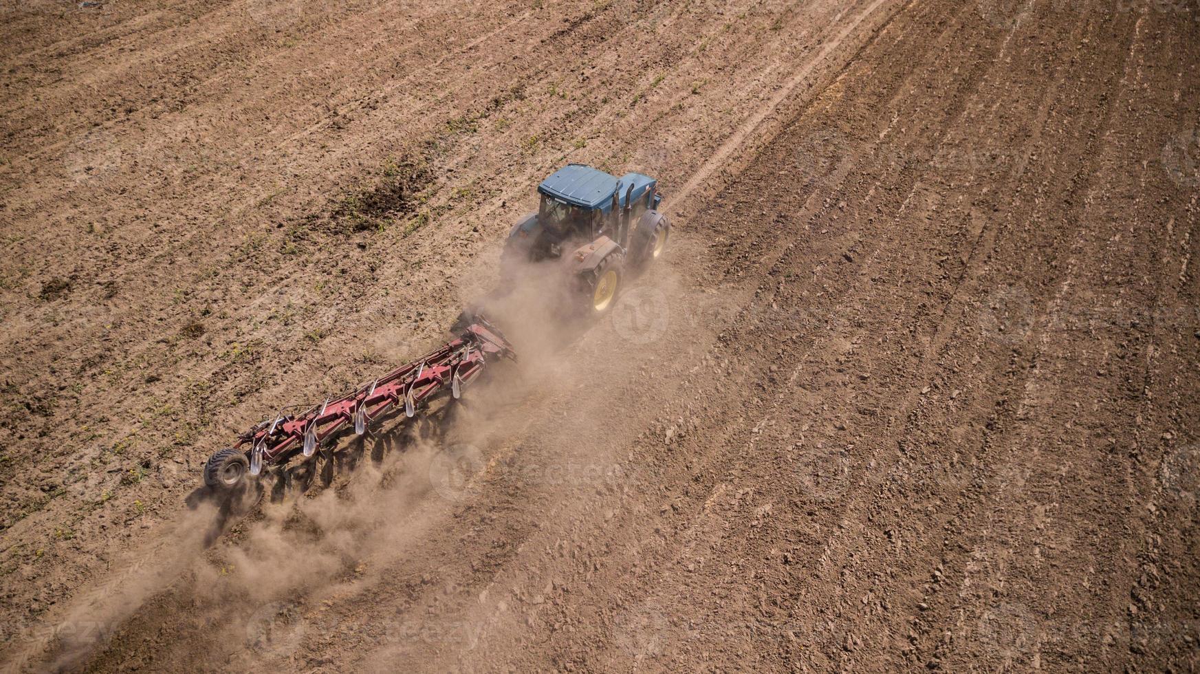 tractor plowing field top view, aerial photography with drone photo