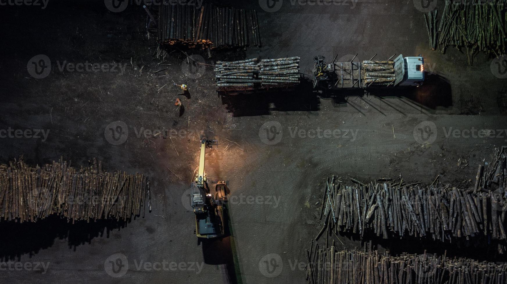 fábrica de carpintería. cargando el bosque en el camión. fotografía aérea nocturna foto