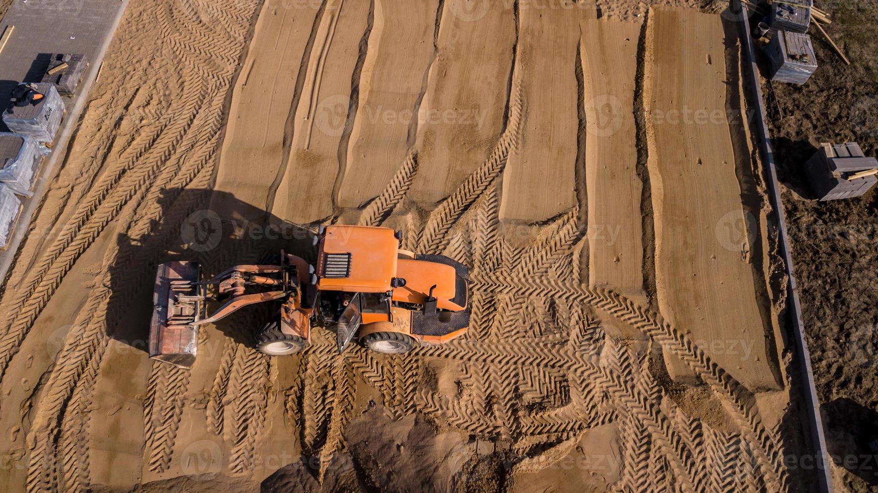 tractor amarillo repara la vista aérea de la carretera foto