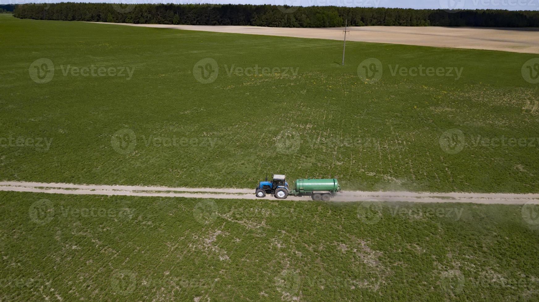 Tractor with trailer fertilizing field with natural manure photo