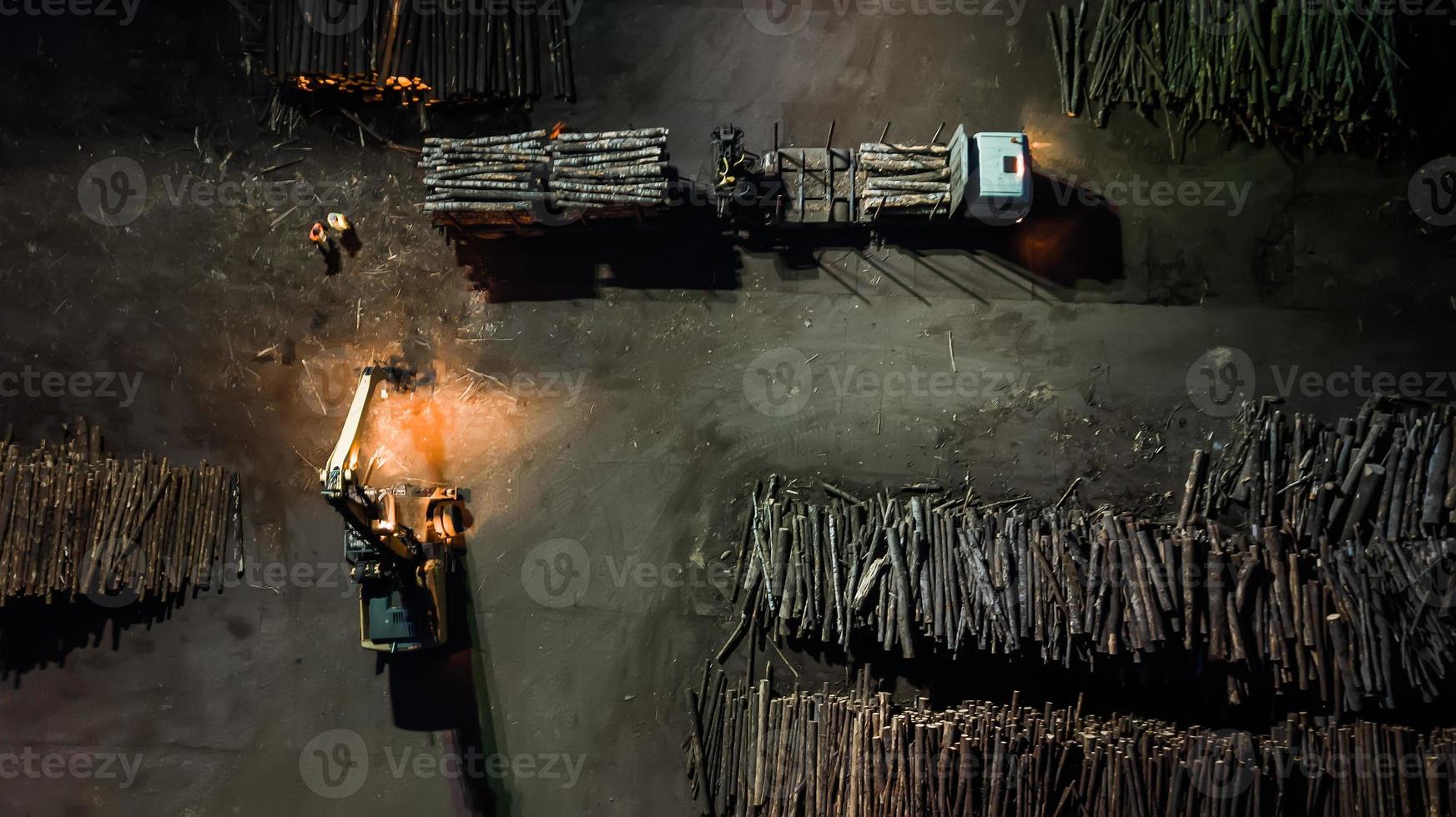 Woodworking factory. Loading the forest in the truck. Night aerial photography photo