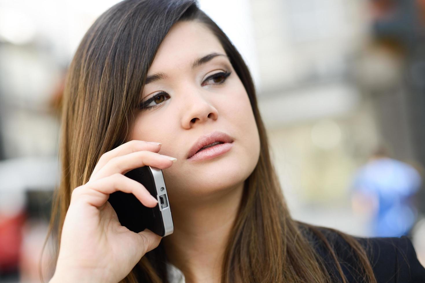 Beautiful japanese business woman in urban background on the phone ...