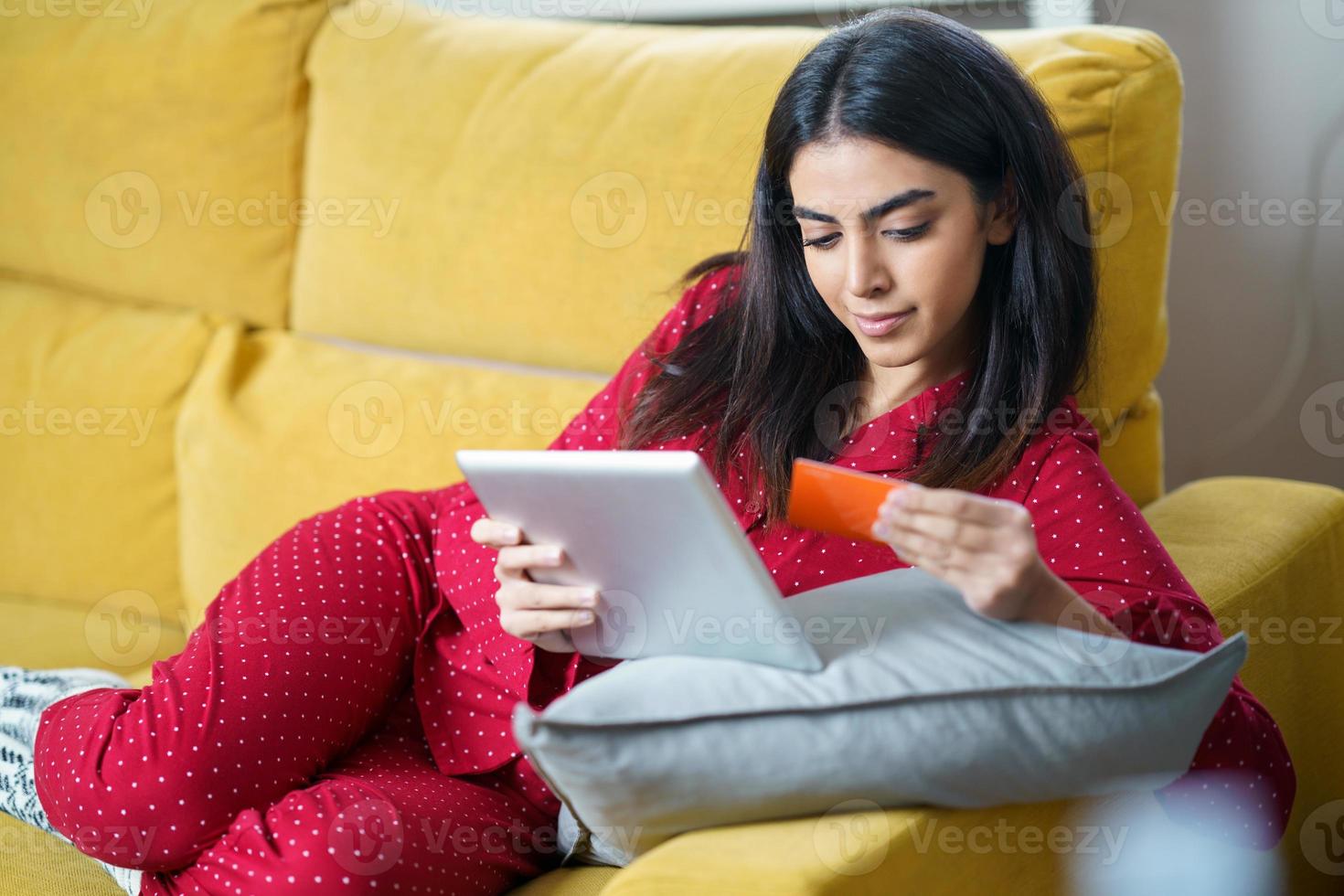 Woman purchasing something online paying with her credit card photo