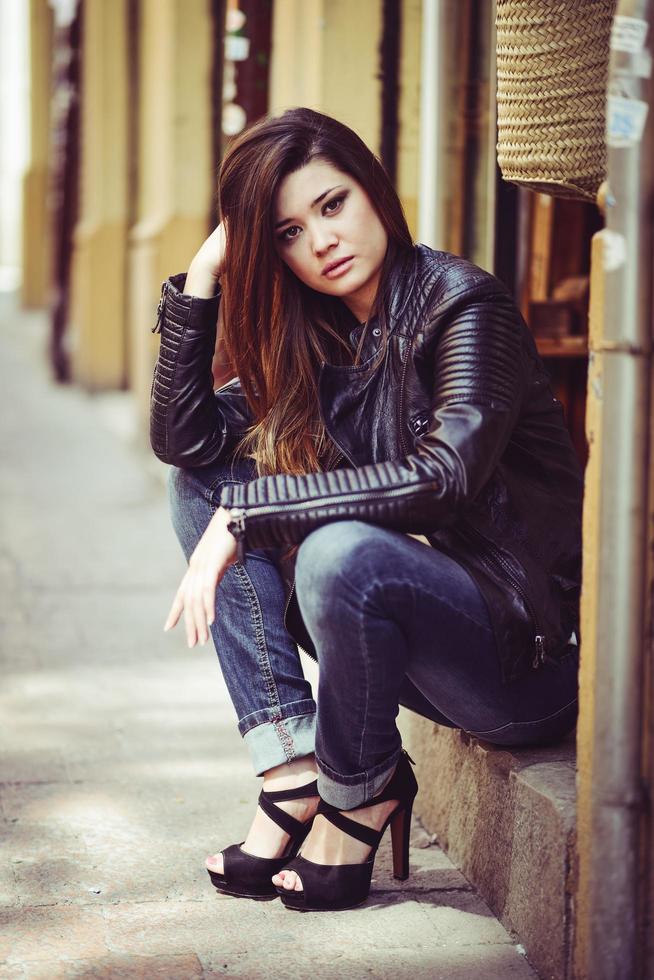 Beautiful japanese woman in urban background wearing leather jacket photo