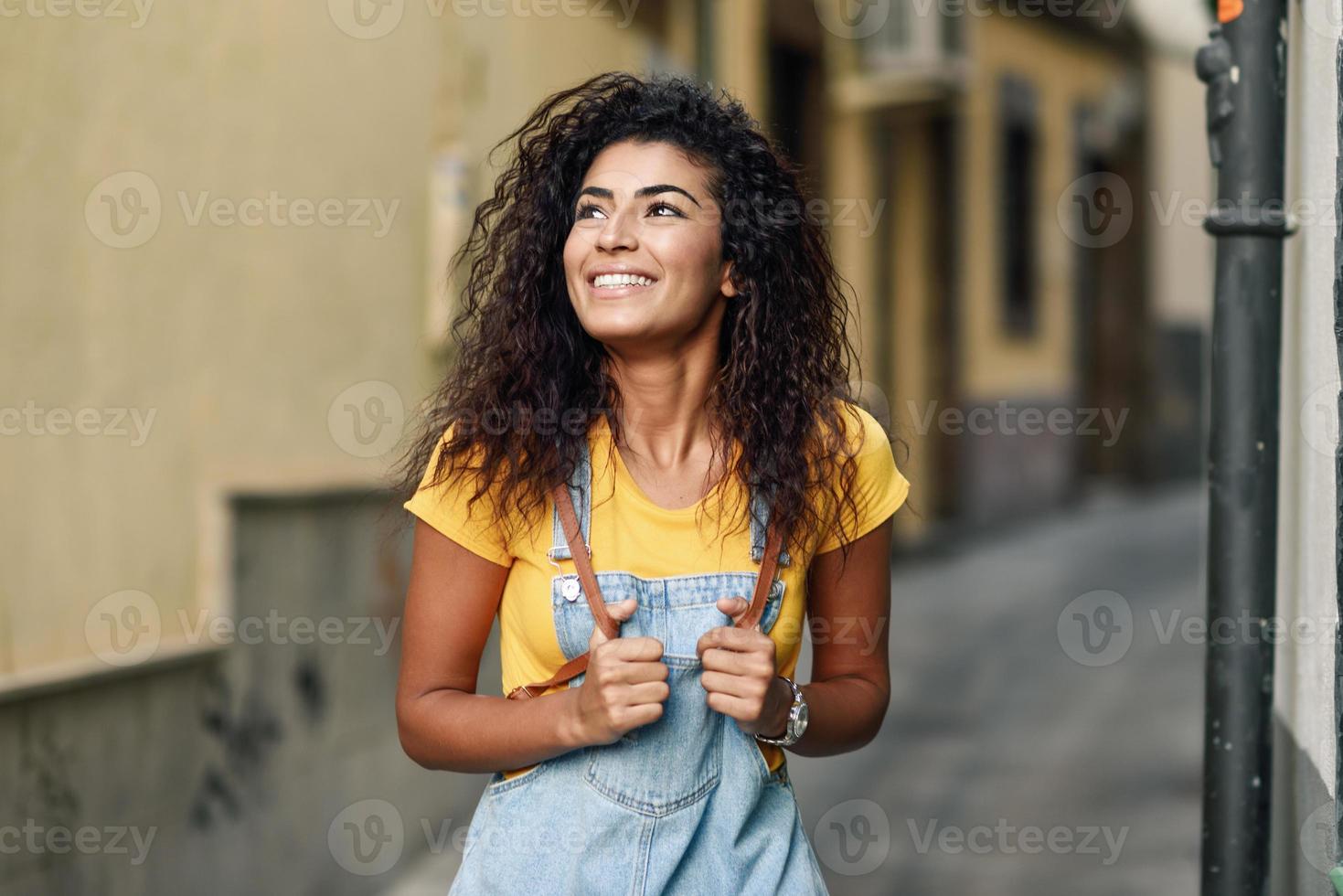 joven norteafricana con peinado rizado negro al aire libre. foto
