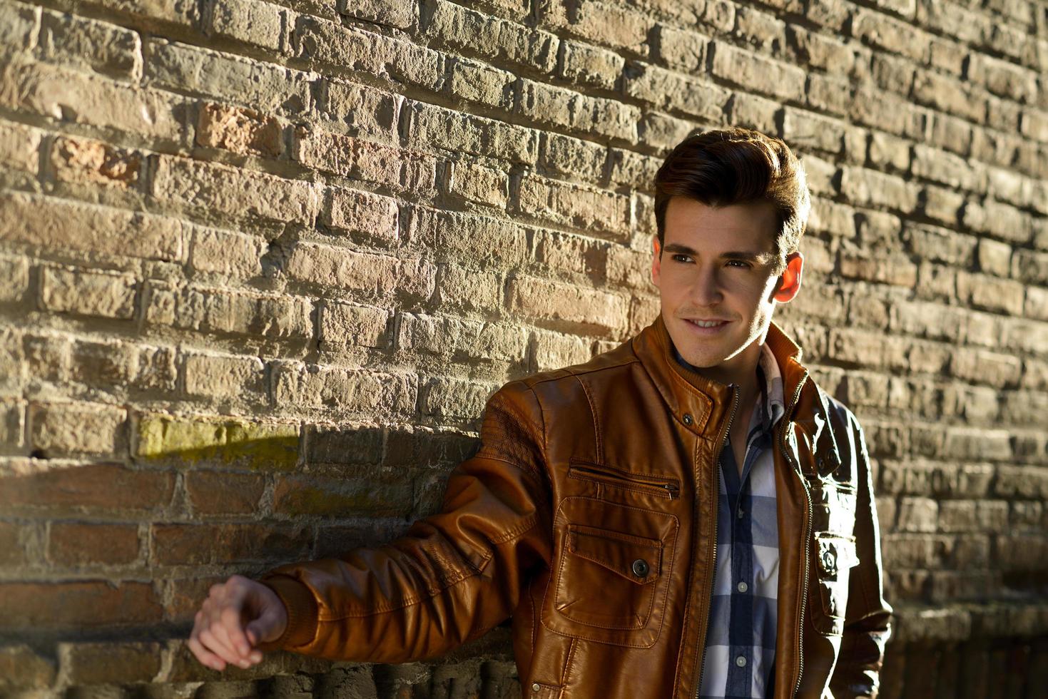 Handsome man with modern hairstyle smiling in urban background photo
