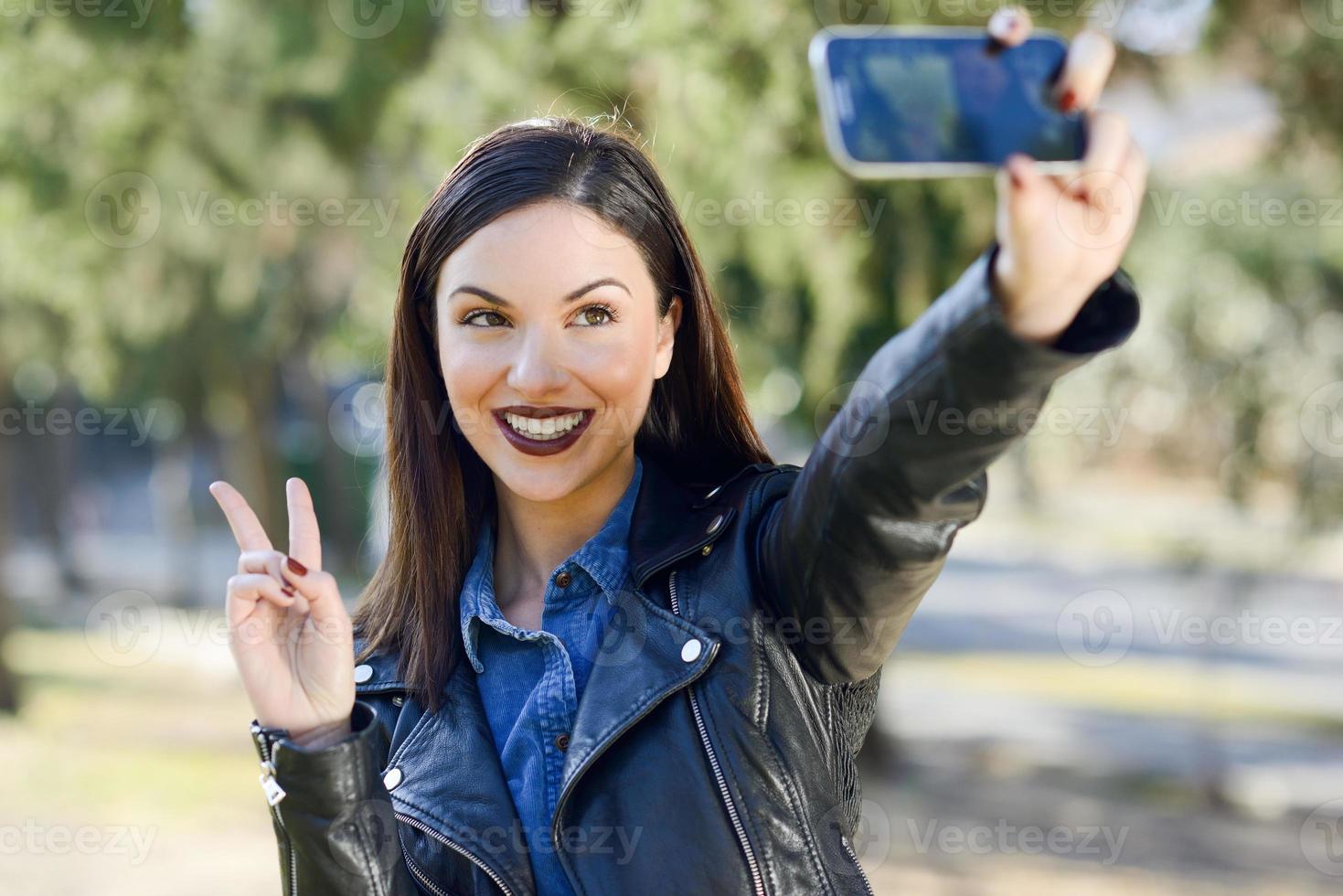 Beautiful young woman selfie in the park photo