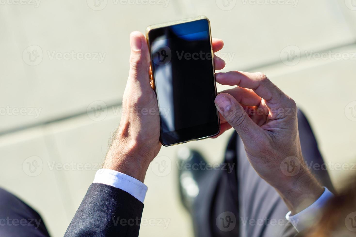 Businessman using his smartphone in the street photo