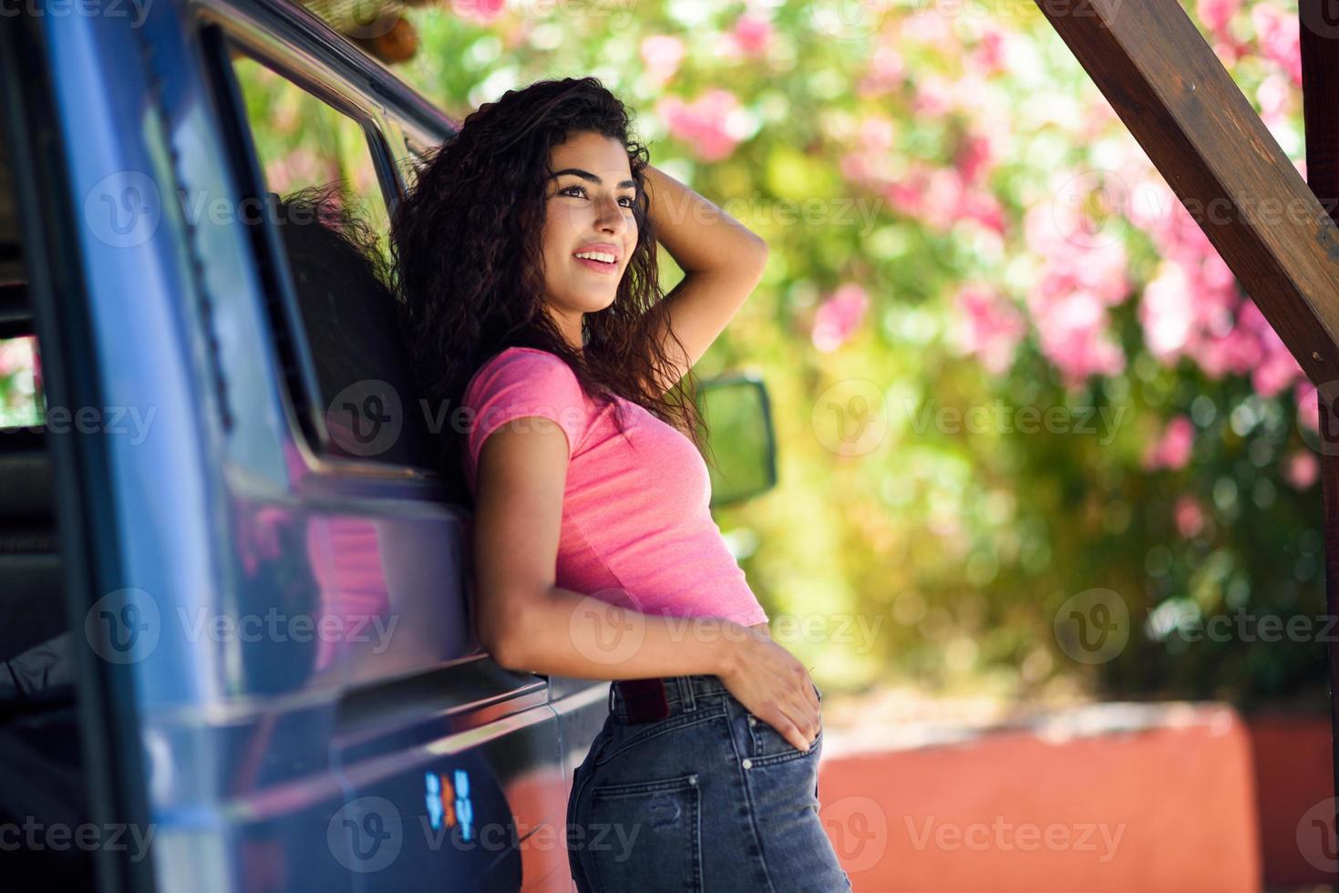 Young woman in a camper van in a beautiful camping with pink flowers photo