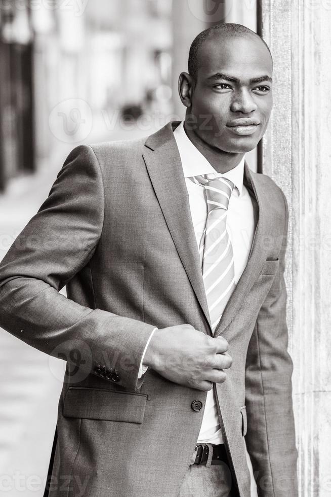 Handsome black man wearing suit in urban background photo