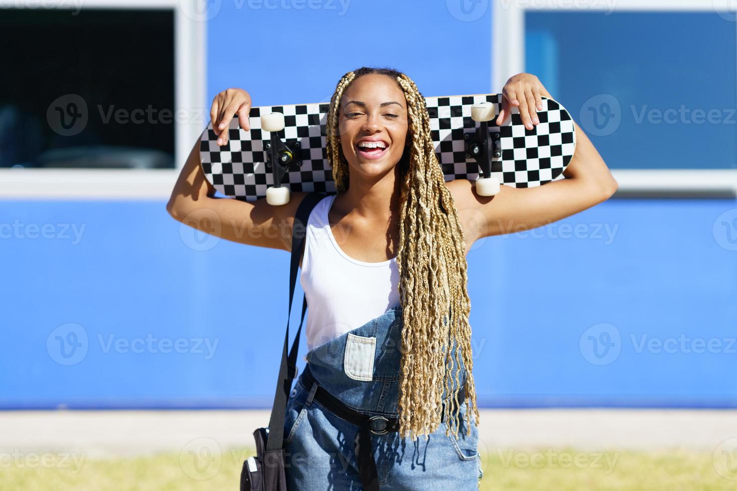 Black woman smiling with coloured braids. Typical African hairstyle. photo