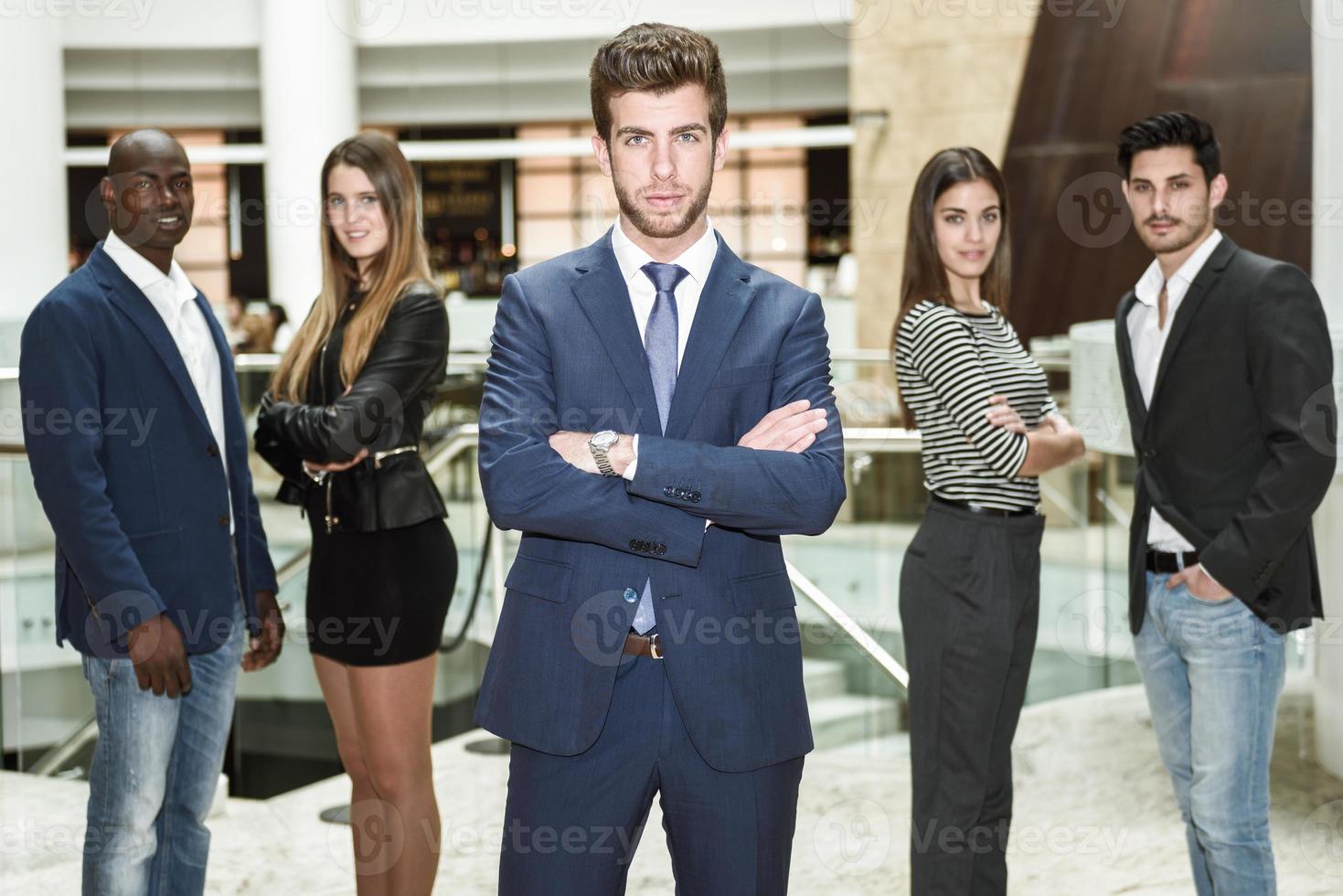 Businessman leader with arms crossed in working environment photo