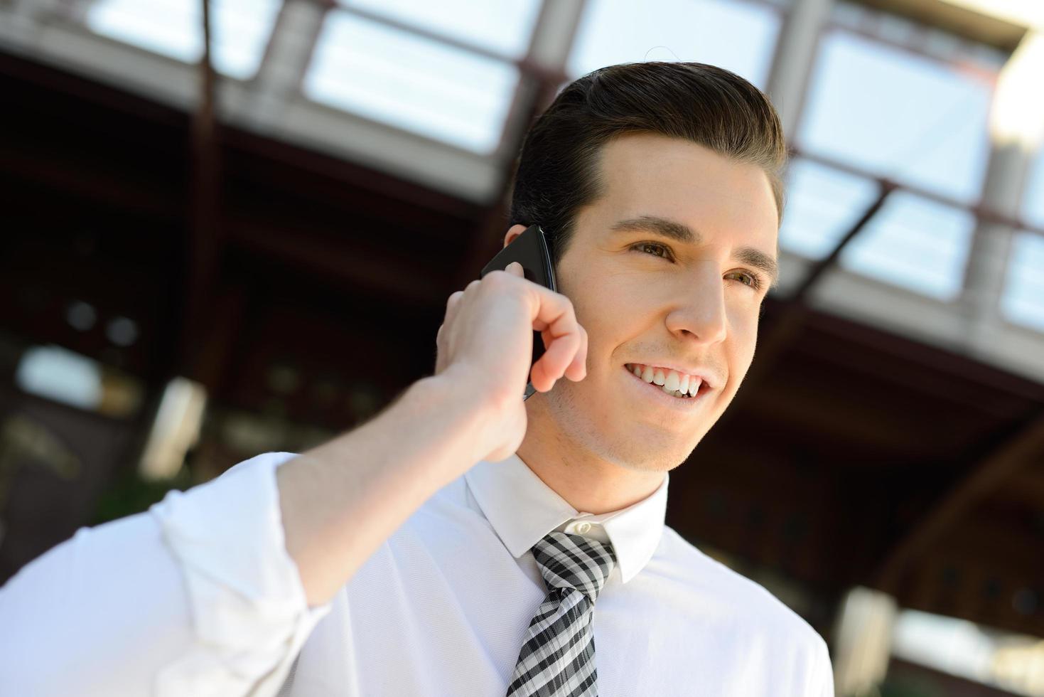 Businessman using a smart phone in an office building photo
