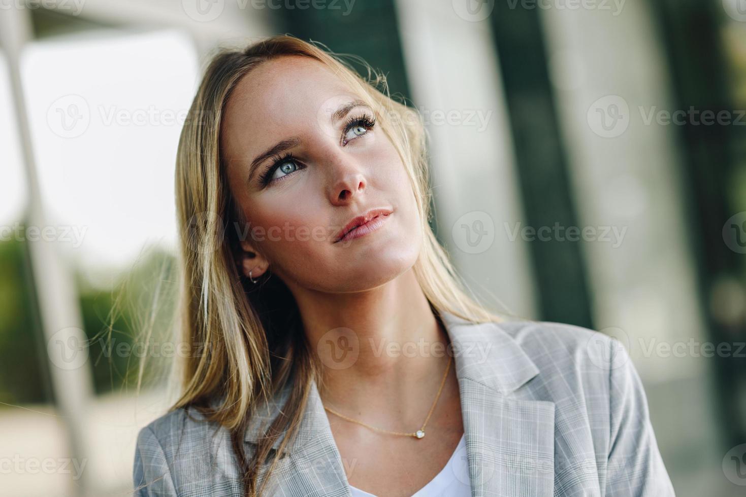 hermosa joven rubia con azul sí en el fondo urbano. foto