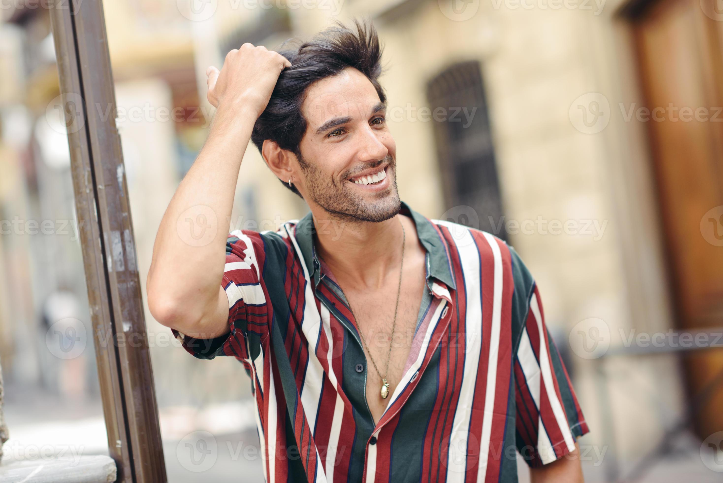 Smiling young man touching his hair wearing casual clothes outdoors 5888454  Stock Photo at Vecteezy