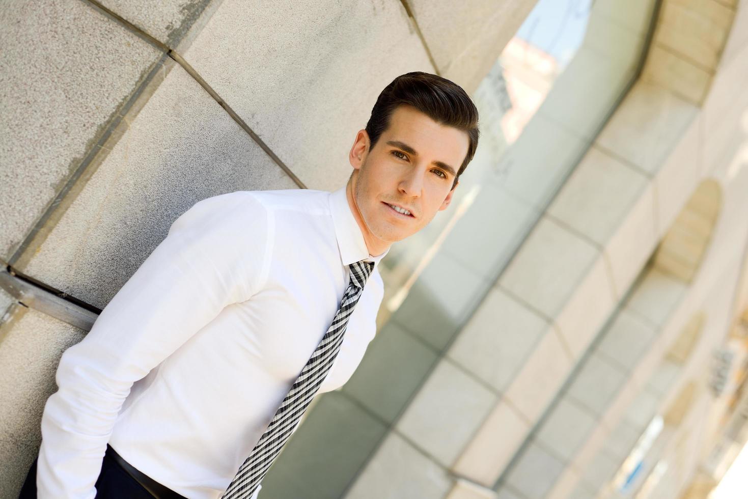 Attractive young businessman in urban background photo