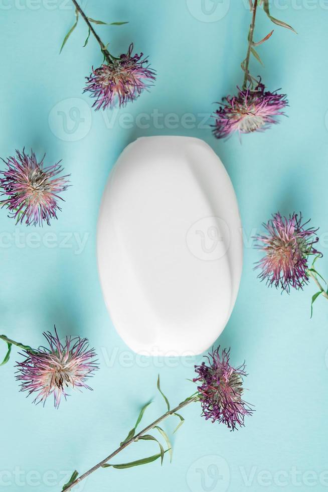 jabón cosmético blanco y flores secas sobre fondo azul. 5889434 Foto de  stock en Vecteezy