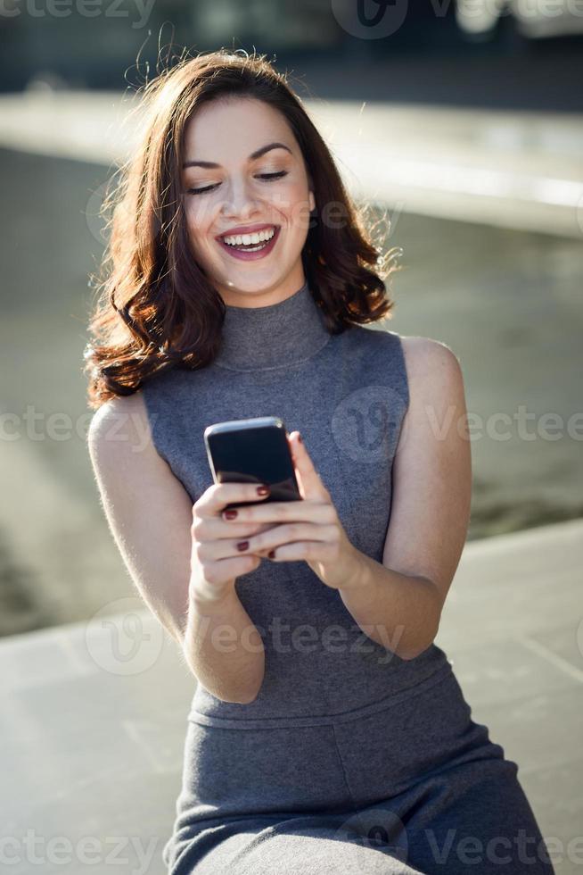 Businesswoman writing with a smartphone in an office building photo