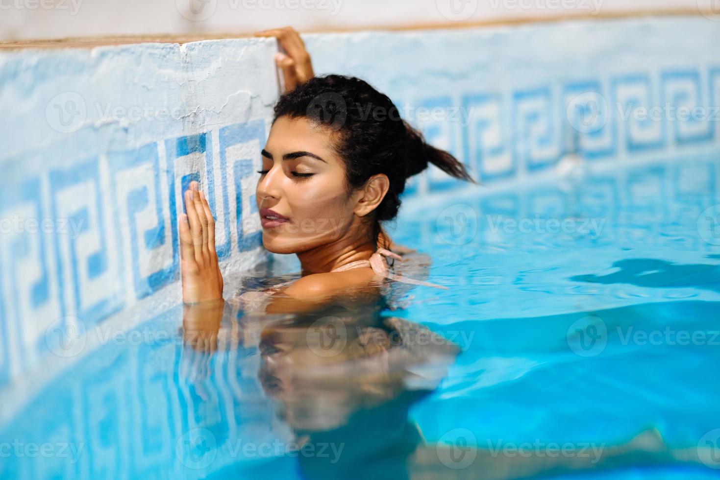 hermosa mujer árabe relajándose en la piscina. foto