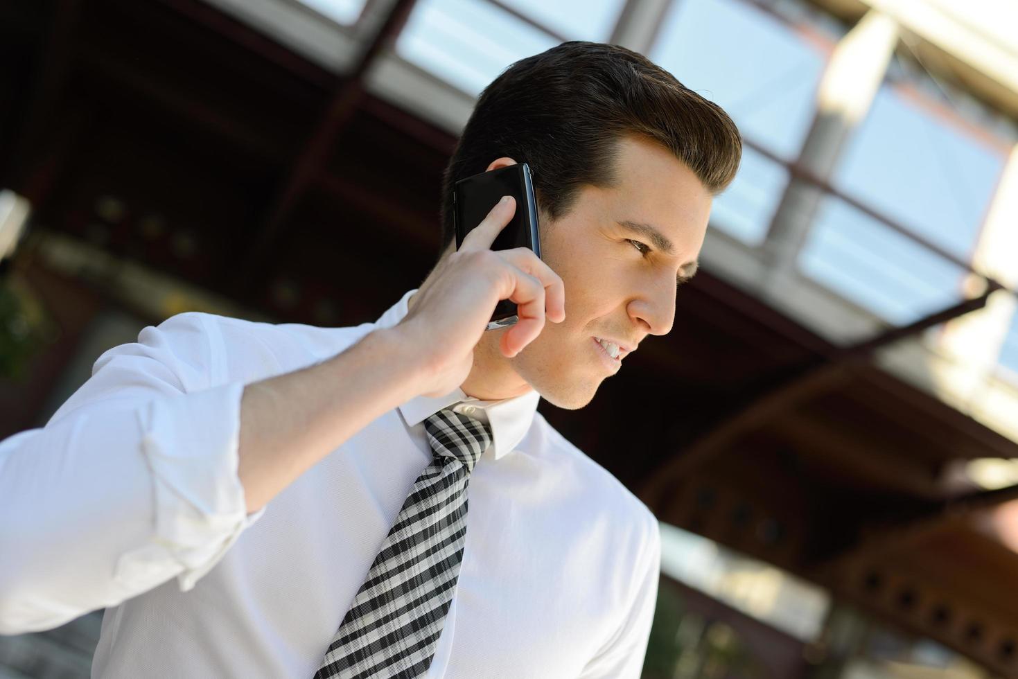 hombre de negocios usando un teléfono inteligente en un edificio de oficinas foto