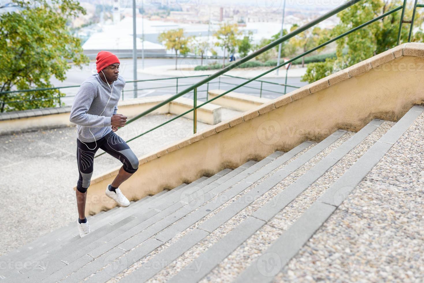 hombre negro corriendo arriba al aire libre en el fondo urbano foto