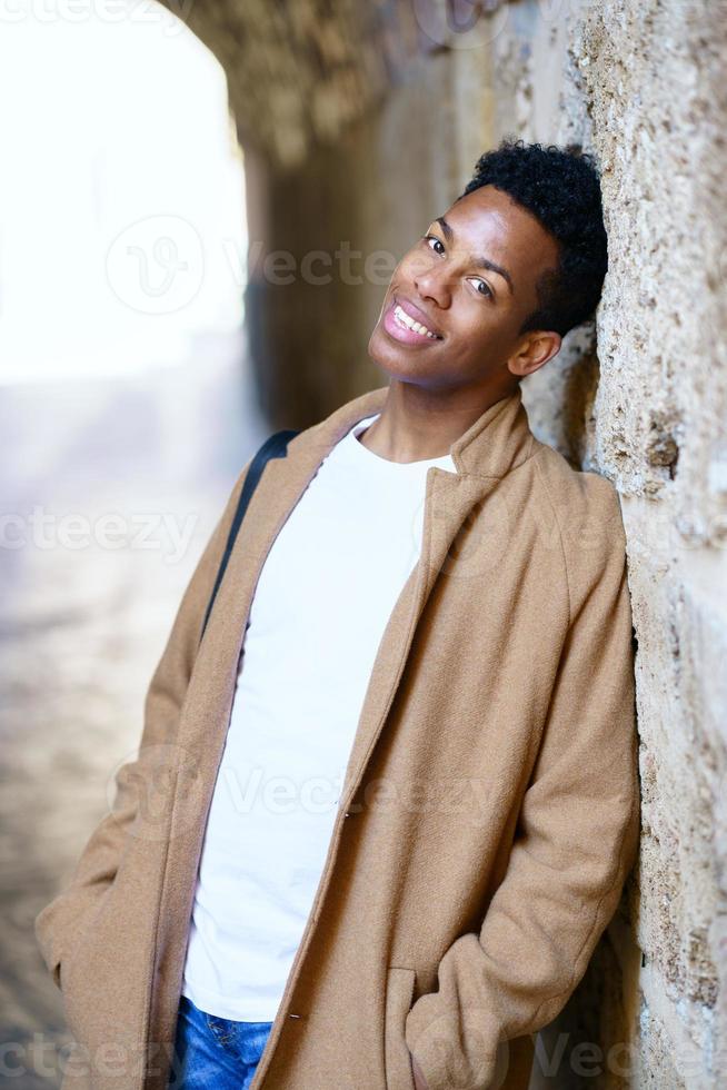 Young black man looking at camera with a happy hopeful look on his face outdoors. photo