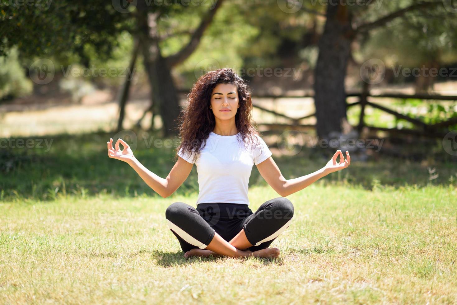 joven árabe haciendo yoga en la naturaleza foto