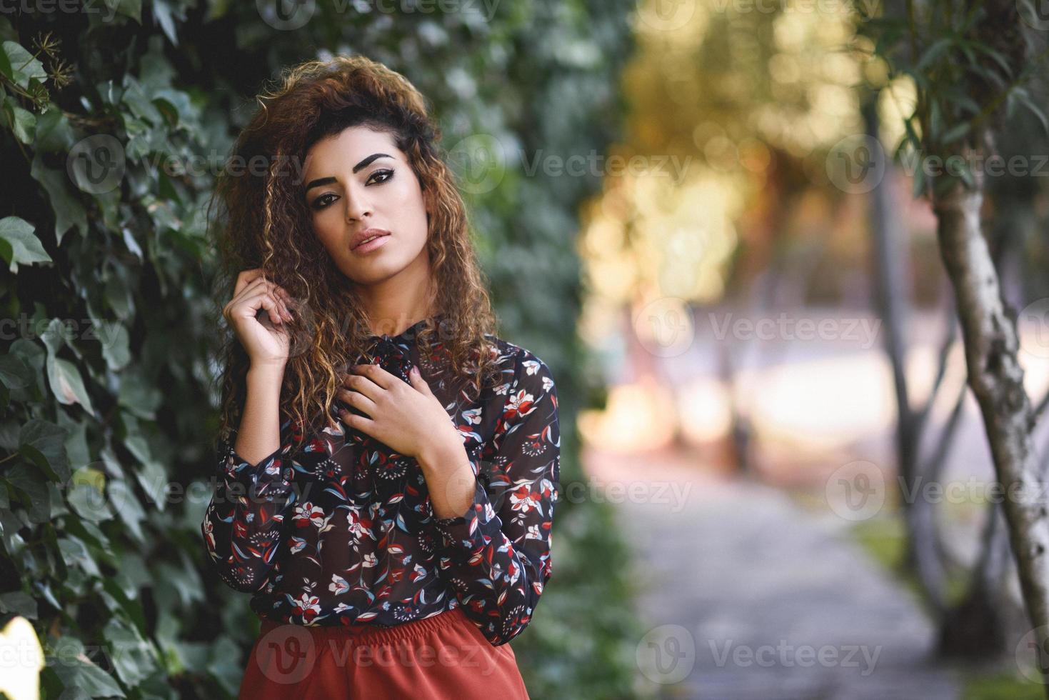 Beautiful young arabic woman with black curly hairstyle. photo