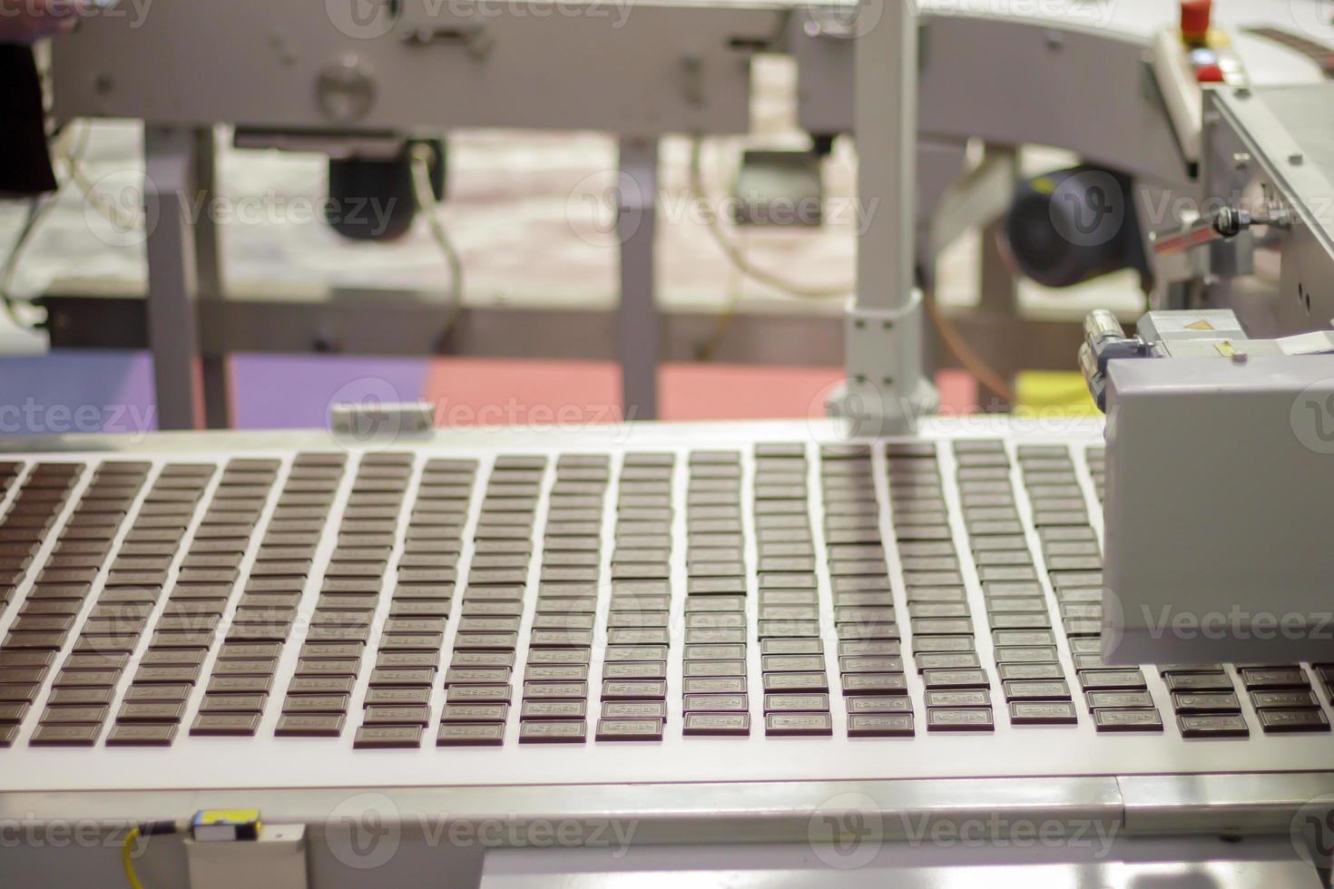 Line for the production of chocolate in an industrial factory. Automatic process in sweets production line during production. Conveyor belt with sweets. Ukraine, Kiev - February 09, 2022. photo