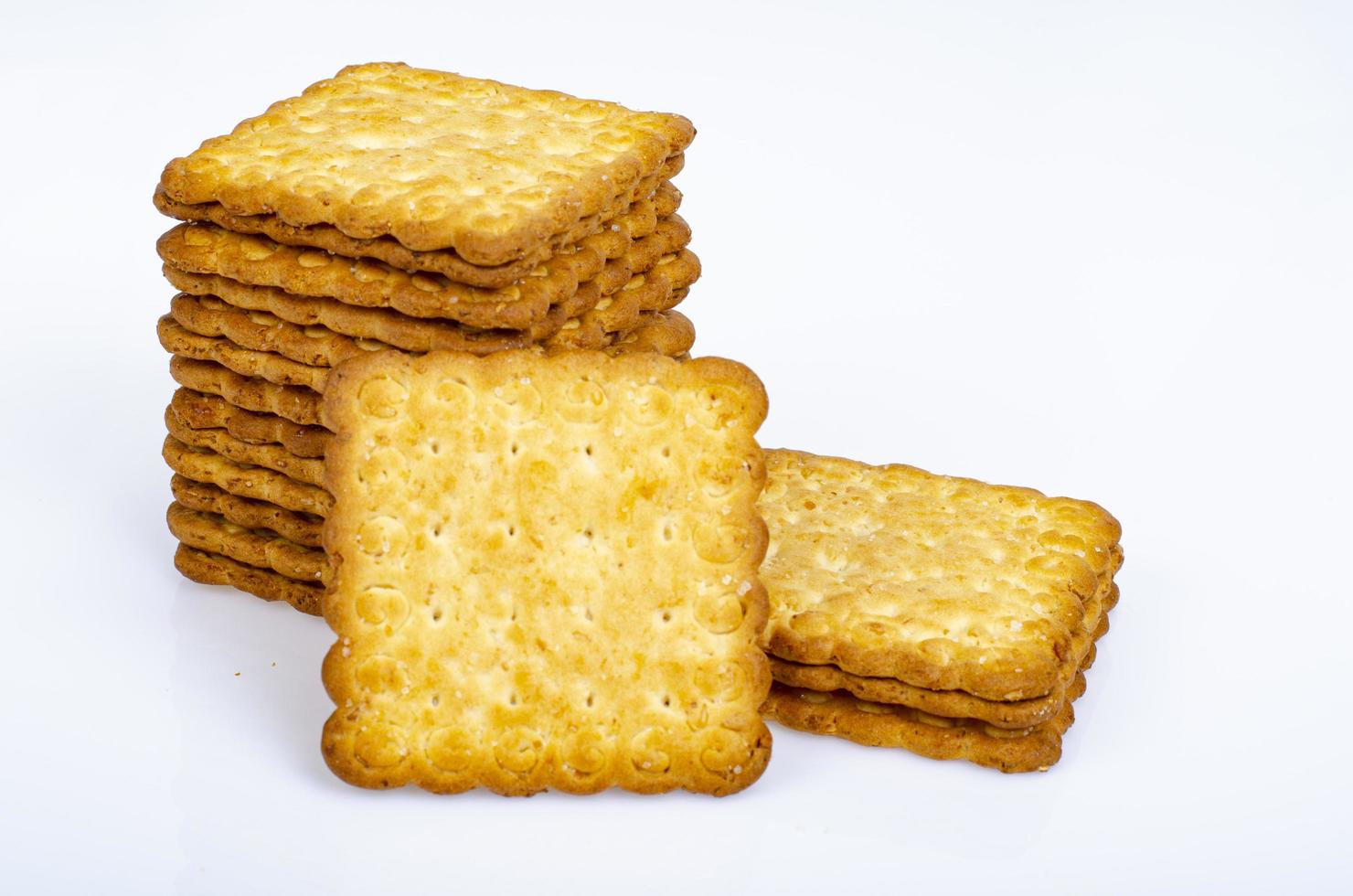 Minimalist pile delicious cookies. Salty biscuit cracker on white background. Studio Photo