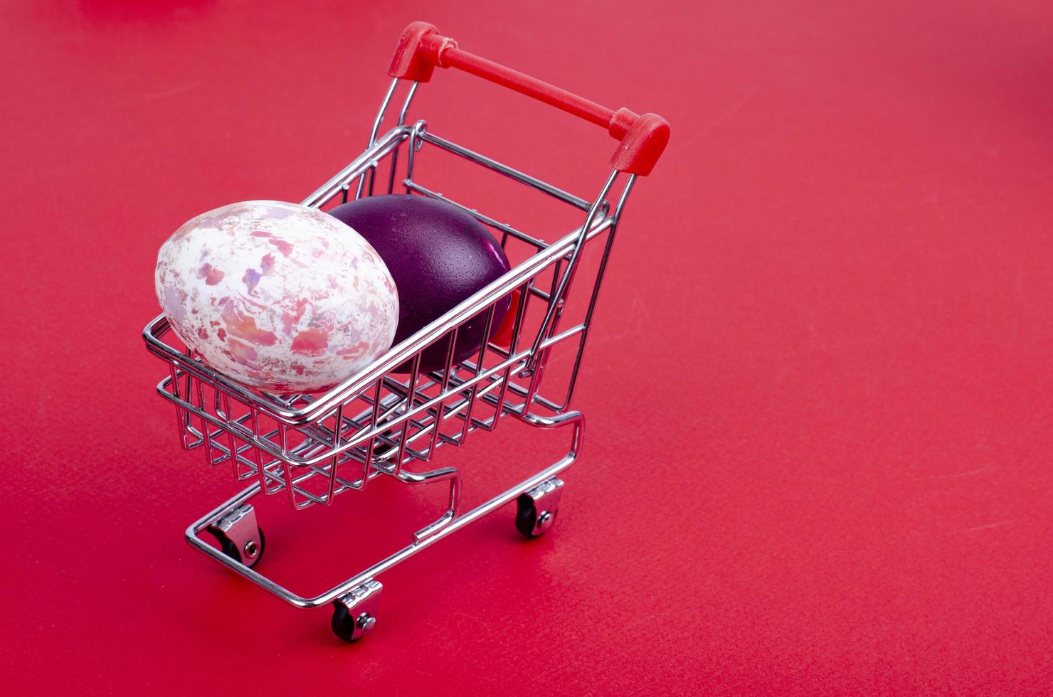 Grocery supermarket cart filled with chicken eggs. Concept of preparing for Easter, buying food. Space for text. Studio Photo