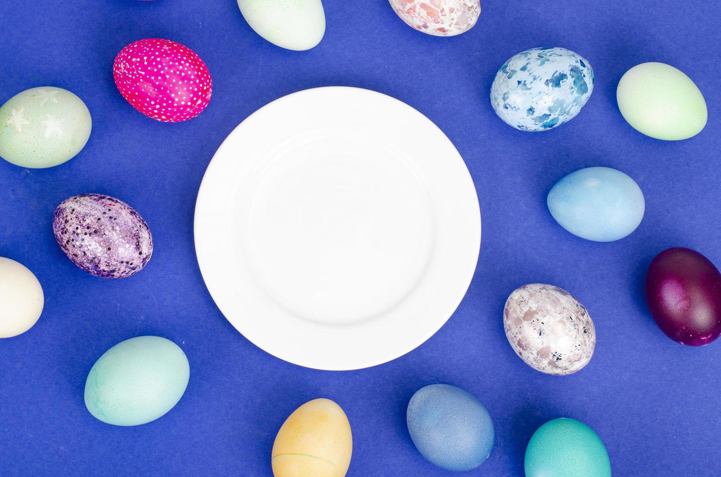 Festive Easter table setting with painted eggs on blue background. Space for text. Studio Photo