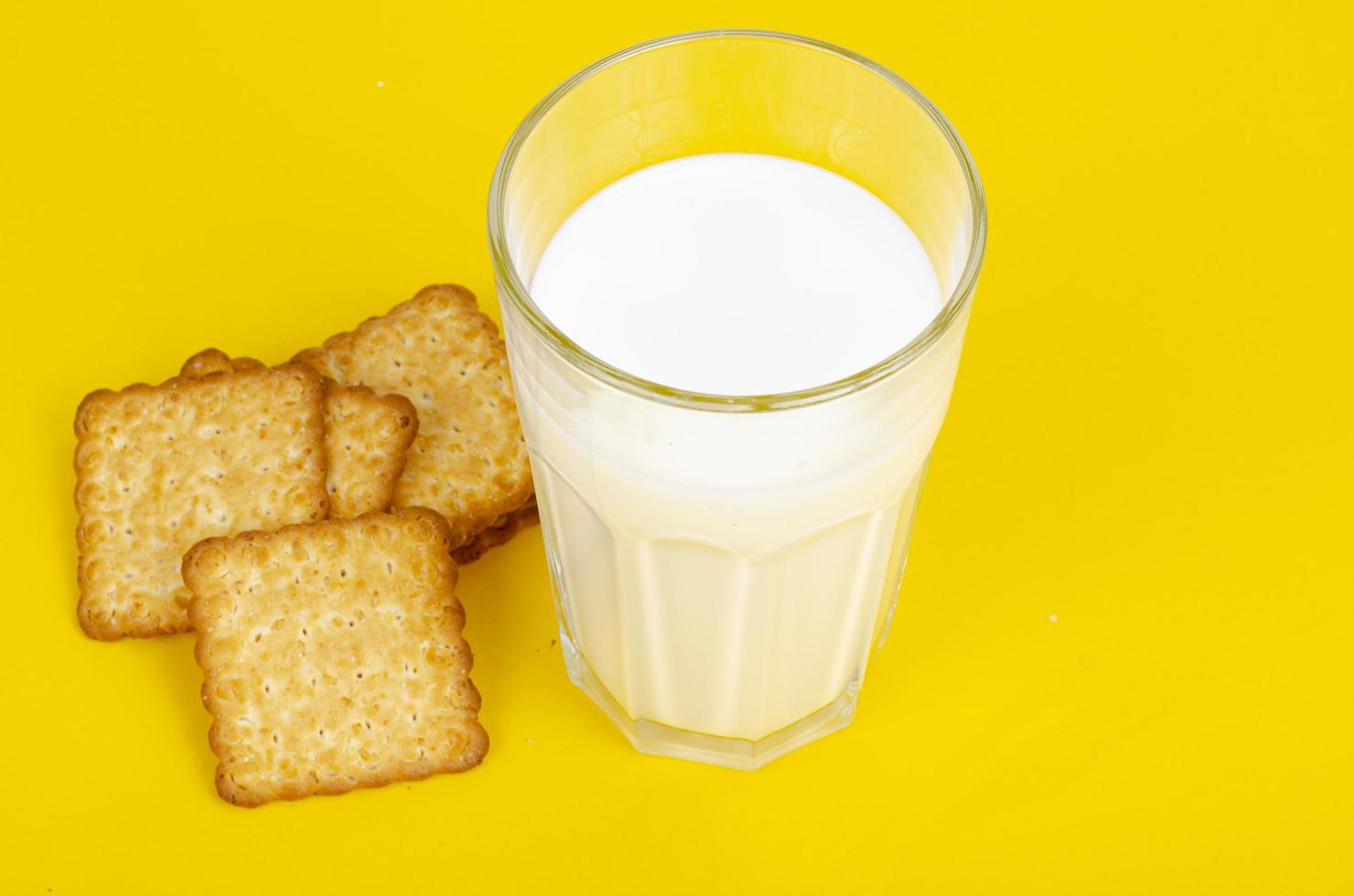 Delicious cookies and glass of milk on bright background. Studio Photo